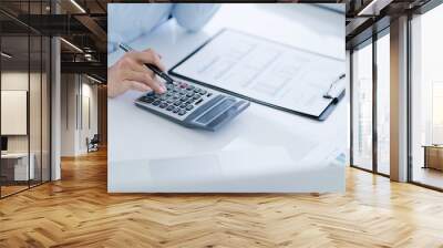 Businesswoman Accountant analyzing investment charts Invoice and pressing calculator buttons over documents. Accounting Bookkeeper Clerk Bank Advisor And Auditor Wall mural